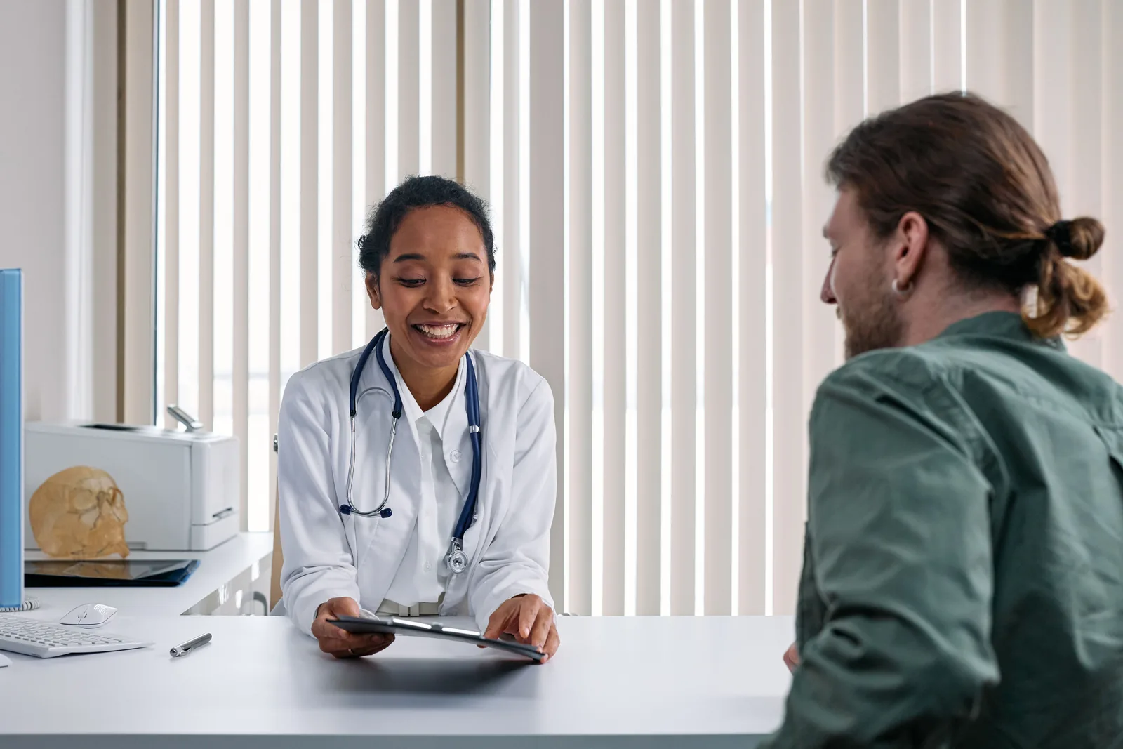 Médica atendiendo a un paciente en un consultorio moderno